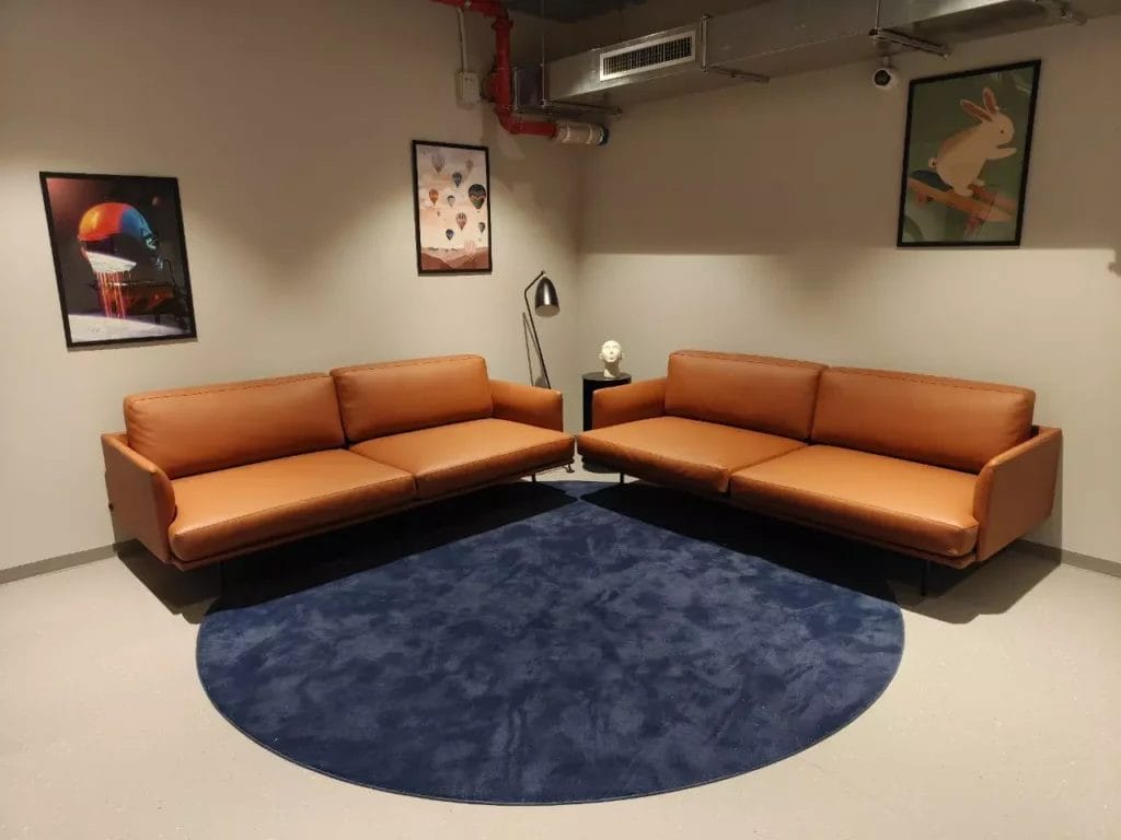 Zona lounge con due divani in pelle al the social hub florence belfiore.
